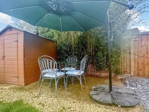 a table and chairs under an umbrella on a patio at Sunrise Villa in Clacton-on-Sea