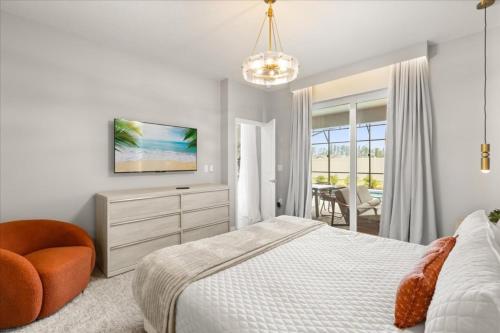 a white bedroom with a bed and a chair at Ev16147 - Coastal Manor in Clermont