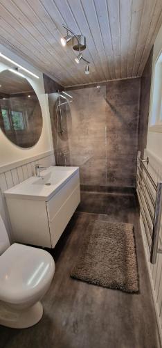 a bathroom with a white sink and a toilet at Stunning Waterfront Property in the Outer Archipelago in Kyrkkobben