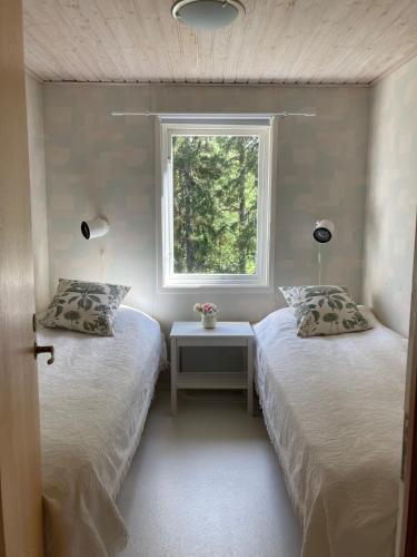 two beds in a room with a window at Stunning Waterfront Property in the Outer Archipelago in Kyrkkobben