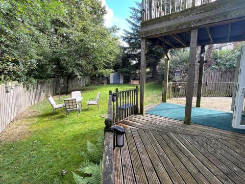 a wooden deck with chairs and a table in a yard at Haven In The Burn in Newburn