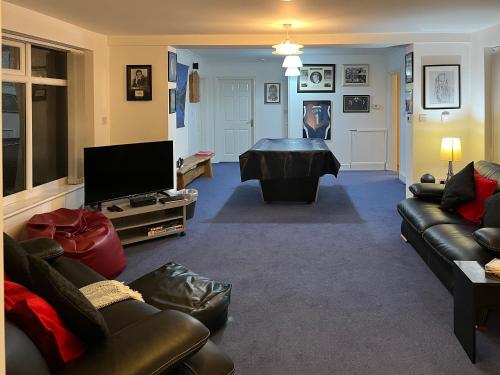 a living room with a couch and a pool table at Haven In The Burn in Newburn