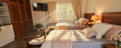 a hotel room with two beds and a kitchen at Rus en Vrede BackPackers Cottage! in Knysna