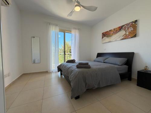 a bedroom with a bed and a ceiling fan at Elysia Park Star in Paphos