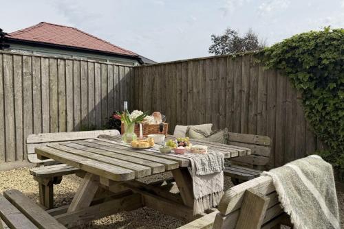a wooden picnic table and bench in a backyard at Littlecot in Weymouth