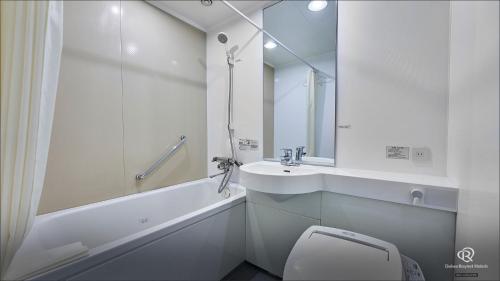 a white bathroom with a sink and a toilet at Daiwa Roynet Hotel Hachinohe in Hachinohe