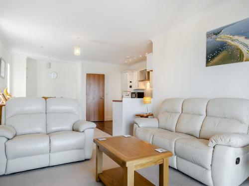 a living room with two white couches and a table at Bay View in Shanklin