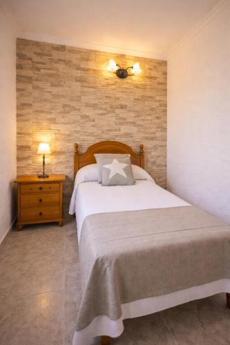a bedroom with a large white bed and a night stand at Hotel Lago Dorado in La Savina