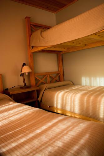 a bedroom with two bunk beds and a lamp at Hotel de Campo Calingasta in Calingasta