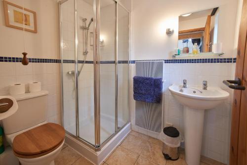 a bathroom with a shower and a toilet and a sink at Barn Cottages at Lacock in Lacock