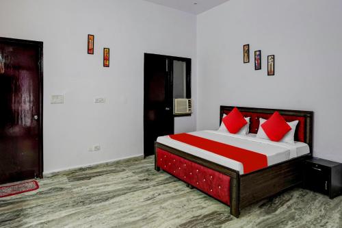 a bedroom with a bed with red pillows at Hotel O Rest & Zone Hotel in Greater Noida