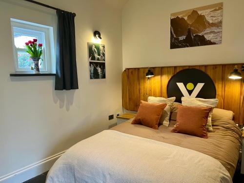 a bedroom with a large bed with a wooden headboard at Loom Cottage, Preseli Venture in Haverfordwest