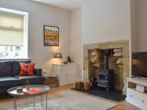 a living room with a couch and a fireplace at Hyem in Amble