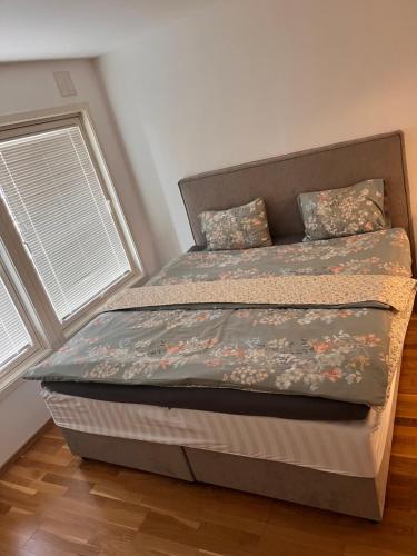 a bed in a bedroom with two windows at Klaus torgårds vei 8b in Oslo