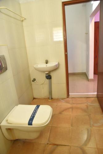 a bathroom with a toilet and a sink at Hotel RD in Perundurai
