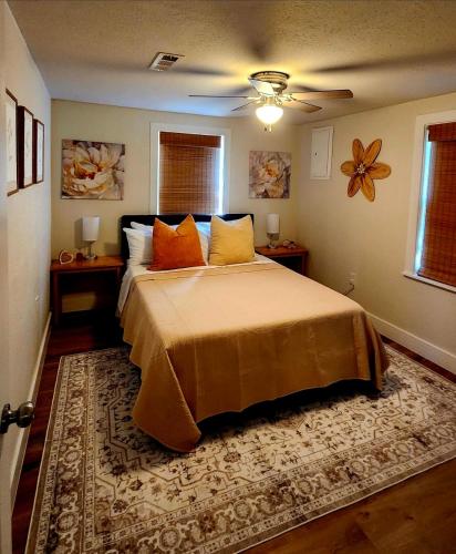 a bedroom with a large bed with orange pillows at Ambervine in Lowell