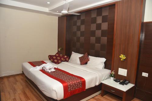 a bedroom with a bed with a dog laying on it at Hotel RD in Perundurai