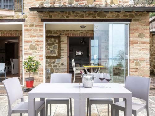 a dining room with a white table and chairs at Villa Oleandra sul Lago by Interhome in San Feliciano