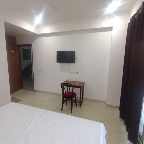 a room with a table and a tv on the wall at Palam residency pg in Gurgaon