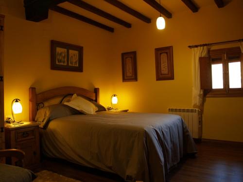 a bedroom with a bed with two lamps on it at La casa del Vado in Hervás