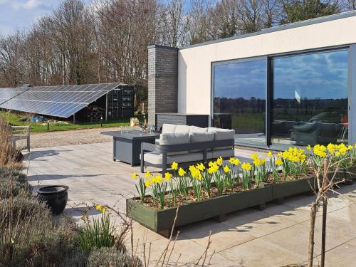 a patio with flowers and a couch and a table at Park Barn in Whittington