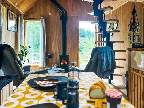 a dining room with a table and a fireplace at Otter Gulley in Eddleston
