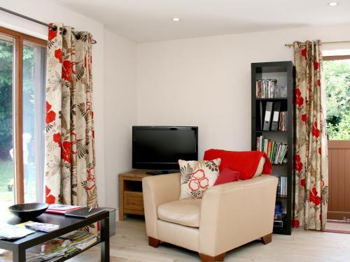 a living room with a chair and a television at Sandhole Barn in Snodland