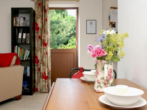 a vase of flowers sitting on a wooden table at Sandhole Barn in Snodland