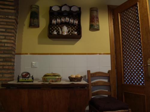 a kitchen with a counter with some items on the wall at La casa del Vado in Hervás