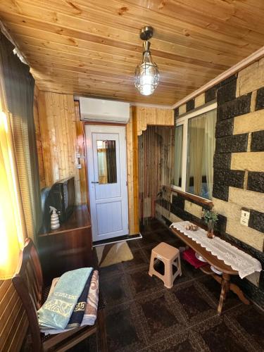a living room with a couch and a table and a tv at Guest House Iura in Sighnaghi