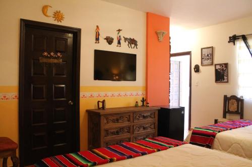 a bedroom with two beds and a tv on the wall at Cielito Lindo in Los Algodones