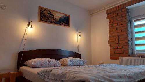 a bedroom with a bed with two pillows on it at Apartmani Bogatić 3 in Bogatić