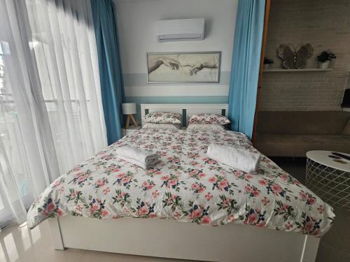 a bedroom with a bed with a floral bedspread at Caesar Resort Lux Studio Apt in Trikomo