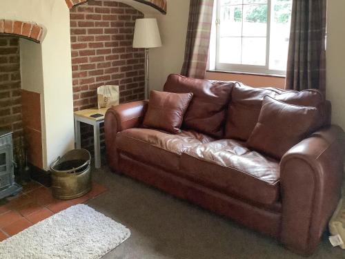 a brown leather couch sitting in a living room at Repton Cottage - 25348 in Findern