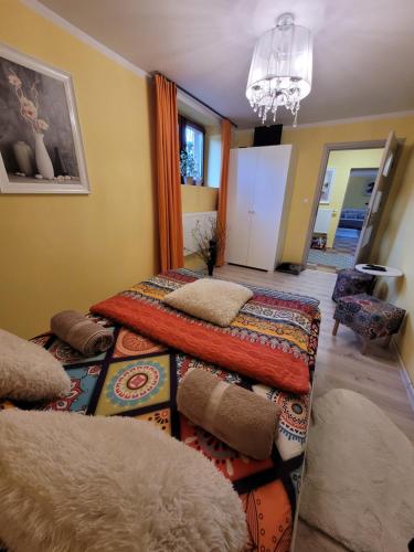 a living room with three beds and a chandelier at Apartament Biała Flaga Podwórko, Grill, Rowery in Charzykowy