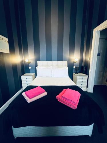 a bedroom with a bed with two pink towels on it at Eliza House in Edinburgh