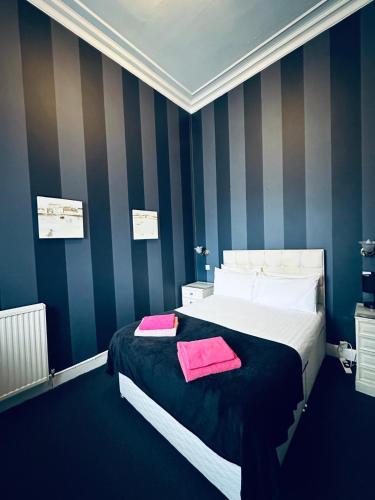 ein Schlafzimmer mit einem Bett, auf dem zwei Handtücher liegen in der Unterkunft Eliza House in Edinburgh
