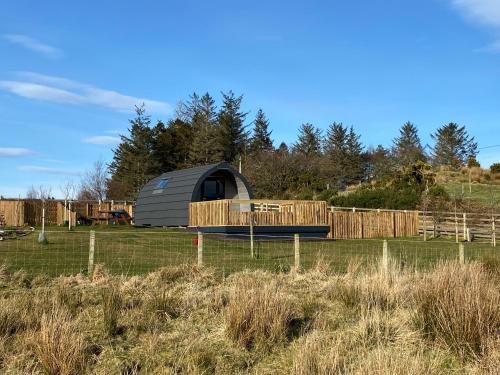 a dome tent in a field next to a fence at Maggie's Cabin in Oban