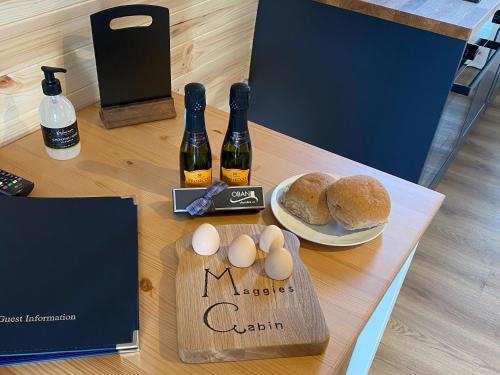 a table with two bottles of wine and eggs and bread at Maggie's Cabin in Oban