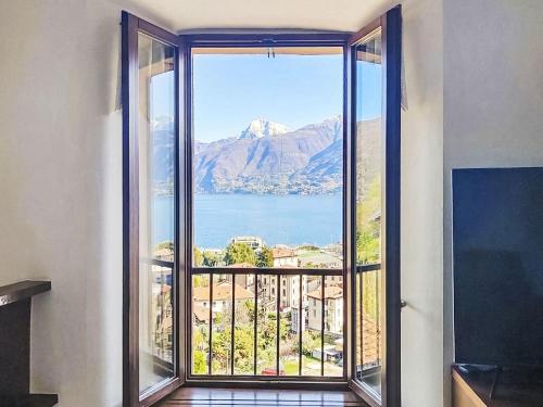 a large window with a view of a mountain at Apartment Lakeview Menaggio by Interhome in Menaggio