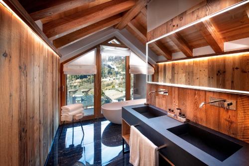 ein Badezimmer mit zwei Waschbecken und einer Badewanne in der Unterkunft Le Massif Hotel & Lodge Courmayeur - The Leading Hotels of the World in Courmayeur