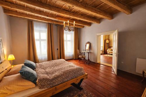 a bedroom with a large bed and wooden floors at Lucerna - dům s duší Příbor in Příbor