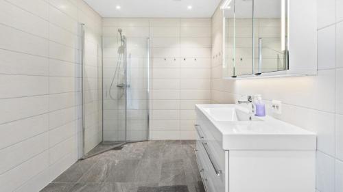 a white bathroom with a sink and a shower at Kvitefjell 35 in Loen
