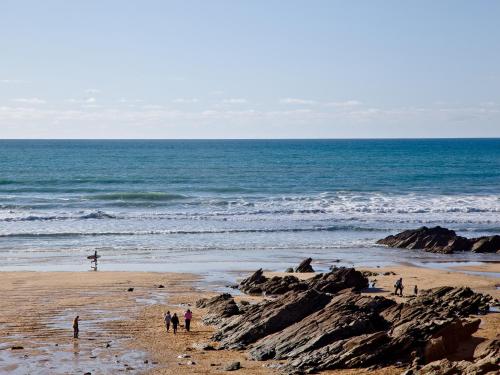 a group of people on a beach near the ocean at 1 Harbour View in Newquay