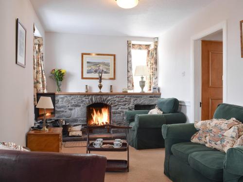 a living room with couches and a fireplace at Castle Peroch-Uk5698 in Logierait