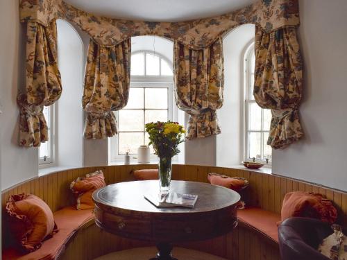 a living room with a table and a window at Castle Peroch-Uk5698 in Logierait