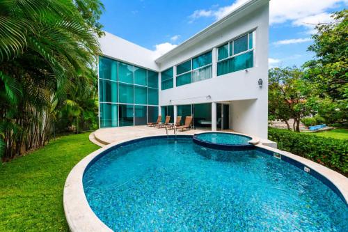 a swimming pool in front of a house at Private Pool Villa, Walk to Beach & 5th Ave in Playa del Carmen