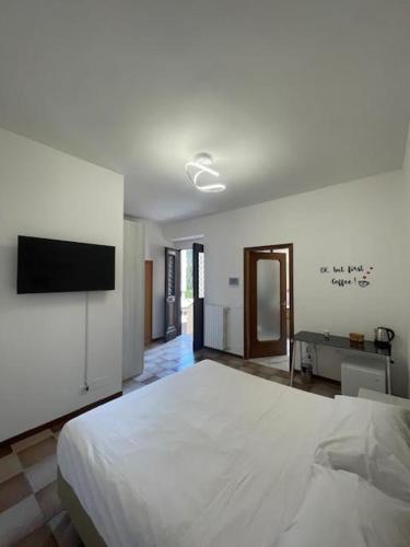 a bedroom with a large white bed and a flat screen tv at Tommy&Gio in Tradate