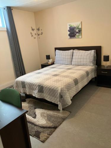 a bedroom with a bed and two tables and a window at Oasis de la rivière in Saguenay