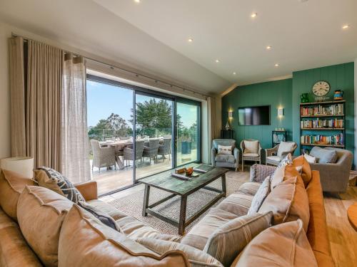 a living room with a large couch and a table at Long Commons in Saint Mawes